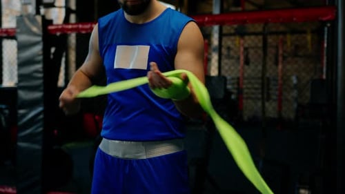 Male boxer wraps his arms before a fight in slow motion Young sportsman prepares for a fight