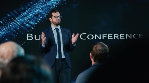 Man Presenting at Business Conference with Audience Members