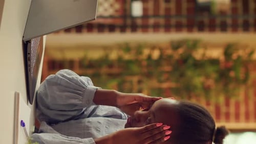 Woman Massaging Temples While Working On Laptop
