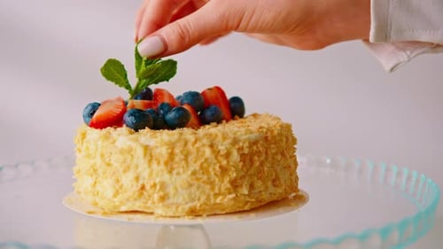 Freshly made delicious puff pastry Napoleon cake decorated by hand with fresh strawberries