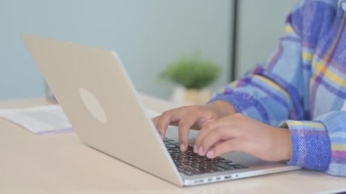 Side View of Young African Woman Working on Laptop