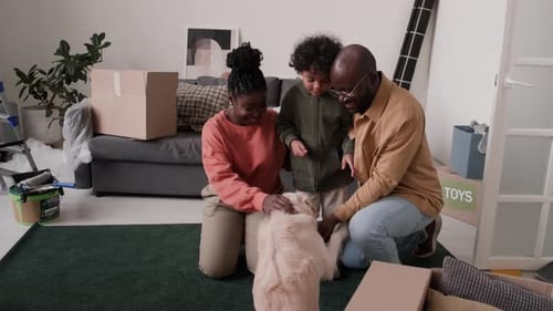 Black Family Petting Dog in New Home with Unpacked Boxes