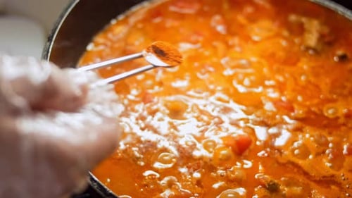 The Woman Puts a Spoonful of Paprika on the Chashushuli