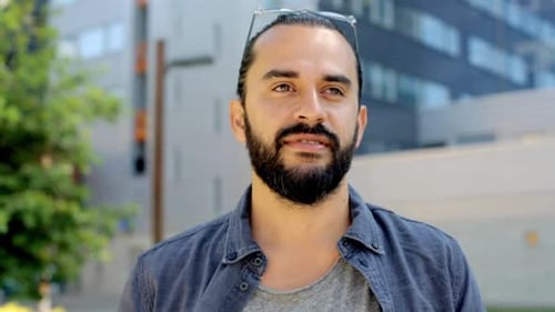 Bearded man smiling in an urban setting