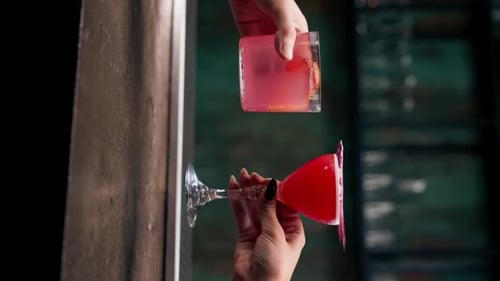 Vertikale Video-Nahaufnahme von zwei Personen, die Cocktails in einer Bar oder einem Disco-Club bei Getränken und Cocktails anfeuern