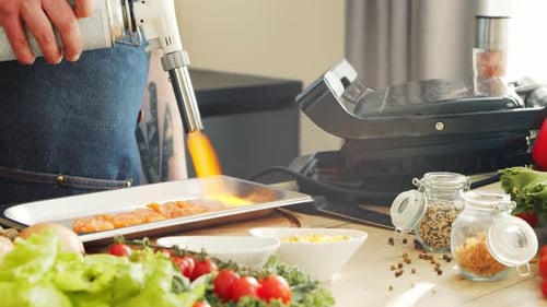 Person Searing Salmon with a Blow Torch