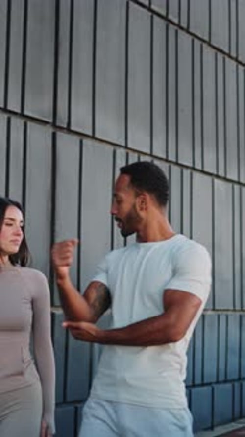 Personal Trainer Explaining Exercises to Client Outdoors