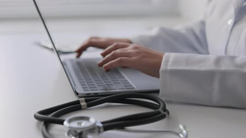 Doctor Typing on Laptop with Stethoscope