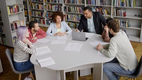 View From Above of Professor Explaining Lesson to a Group of Diverse Students in the Library Campus