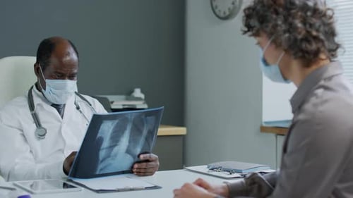 Doctor Discusses X-Ray Results with Patient in Office