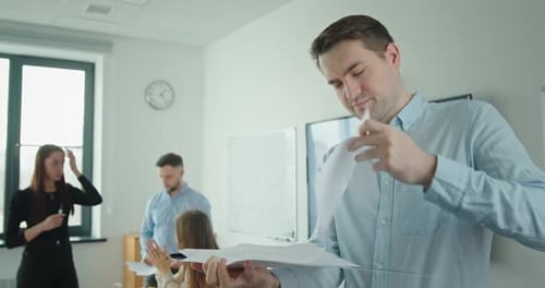Young Successful Male Businessman Looking at Paper Documents Smiling Showing Class Thumb Up on