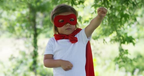 Child Dressed Up as Superhero Raises Fist