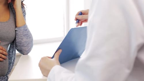 Pregnant woman talks with healthcare professional in office