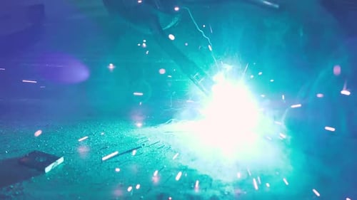 Nahaufnahme von Metall, Stahl und Eisen mit einem Schweißgerät, helle Funken und Blitze in sehr Sekunden
