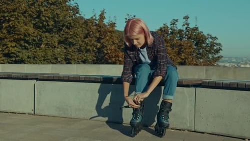 Young Woman Preparing to Rollerblade in Urban Park