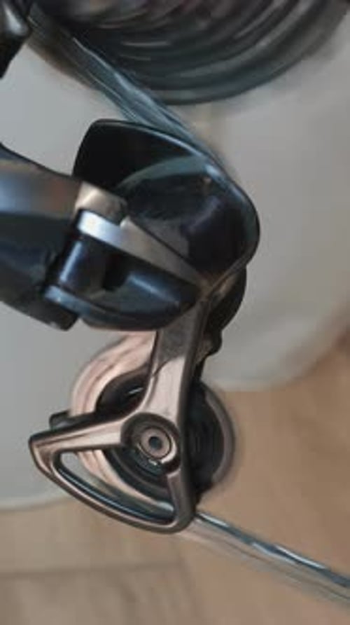 Drivetrain and bicycle wheel rotating, close up of details. Vertical video