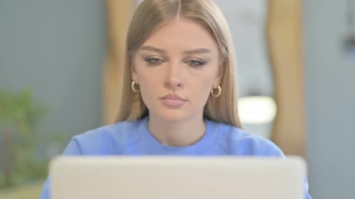 Close Up of Woman Shaking Head in Rejection while Working on Laptop