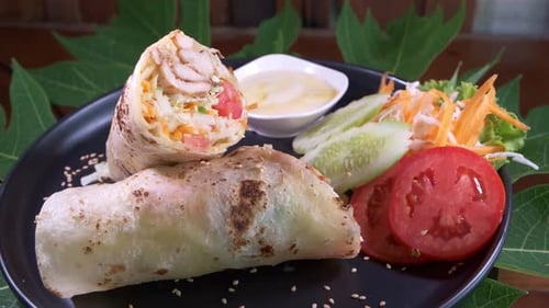 Chicken Kebab Wrap on a Black Plate Close Up Spinning