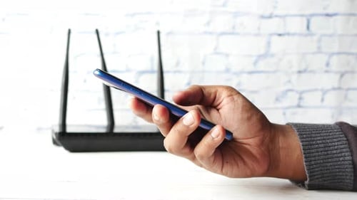 WiFi-WLAN und Smartphone in der Hand auf dem Tisch