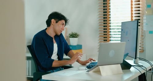 Young Man Working at Desk in Home Office