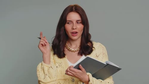 Woman Gets Idea and Writes in Notebook