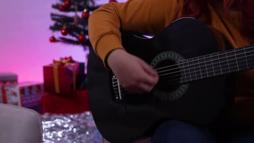 Close up Playing Guitar in Holiday Setting