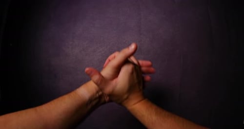 Men's hands come together close up gesture captured from left side looking gracefully in front of ca