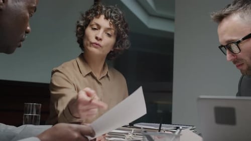 Professionals Collaborating on Documents in Office