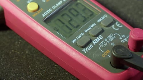Closeup view: Electronic multimeter screen cycles through readings