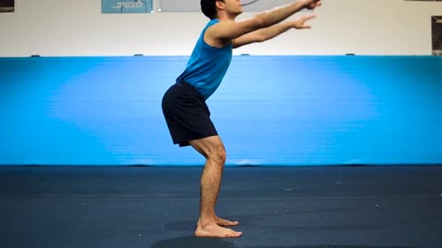 a still shot of a guy doing squats
in a gymnastics gym