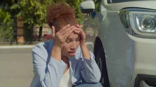 Portrait of Upset African American Female Looking at Car Scratch After Accident