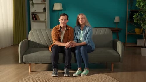 Happy Couple Holding Hands Smiling on Couch