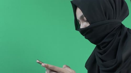 Hijab Muslim Women Texting On Mobile Phone. Side View Green Screen, Locked Off