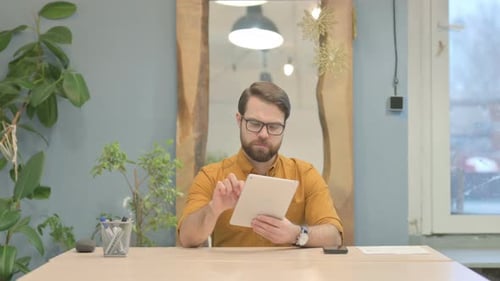 Man Using Tablet in Office During Daytime