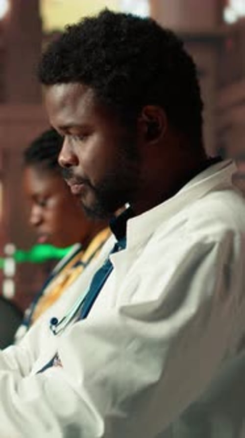 Vertical Video African American Medical Student Reads Under Green Lamps in a Library