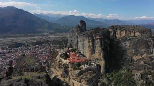 Un monasterio construido sobre una formación rocosa se eleva sobre un valle