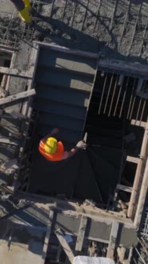 Vertical Video of Engineers Reviewing Plans While Workers and a Crane Collaborate on Construction