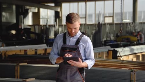 Professioneller Arbeiter der Schwerindustrie, der Sicherheitsuniform trägt, verwendet Tablet-Computer