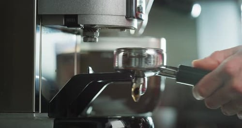 Macro of the hands of a barman while he is making coffee with the coffee machine, in a bar. Concep