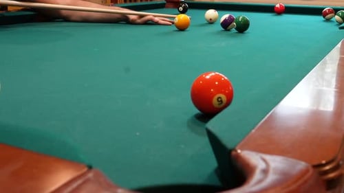 Man Playing 8 Ball Pool Shoots Brown Striped 15 Ball into Corner Pocket on a Brunswick Table with Gr