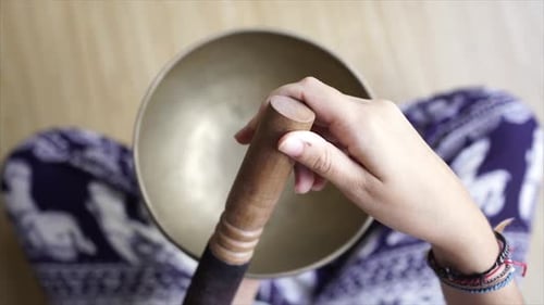 Hands Playing a Singing Bowl Overhead