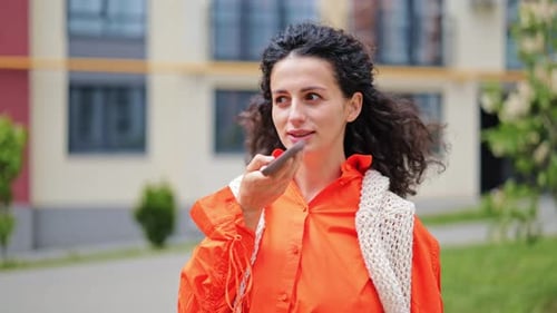 Woman Uses Voice Memo on Smartphone Outdoors