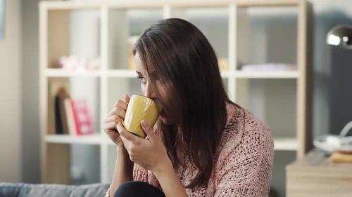 Woman Enjoying Warm Beverage in Comfortable Home Setting