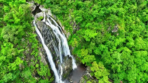 Beautiful waterfall in the green tropical forest. Drone aerial view.