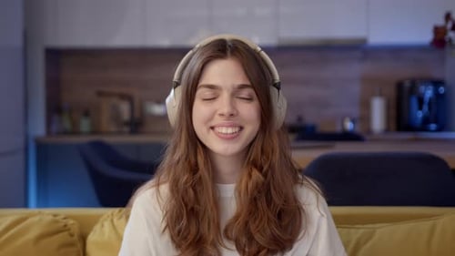 Woman Puts On Headphones and Listens to Music