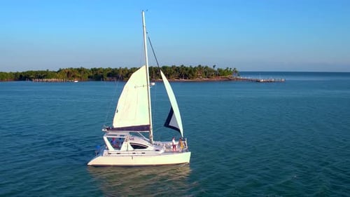 Couple sailing a catamaran in the bahamas tropical turquoise paradise