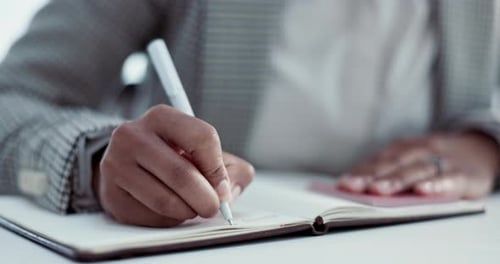 Hand Writing in Open Notebook with White Pen