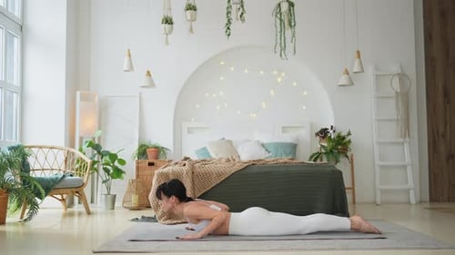 Woman Doing Yoga in Bright Bedroom