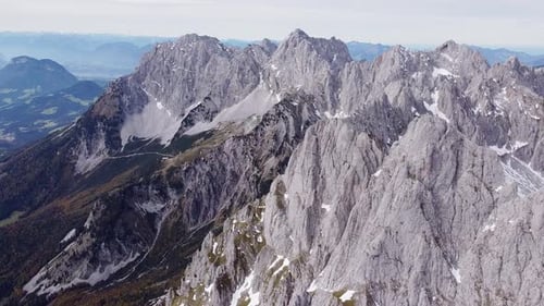 Aerial of steep rocky alpine mountain top peaks, epic landscape drone scenery view flying orbit