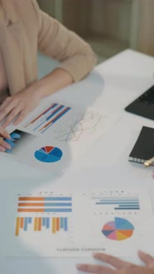 Adults Review Charts and Graphs in Office